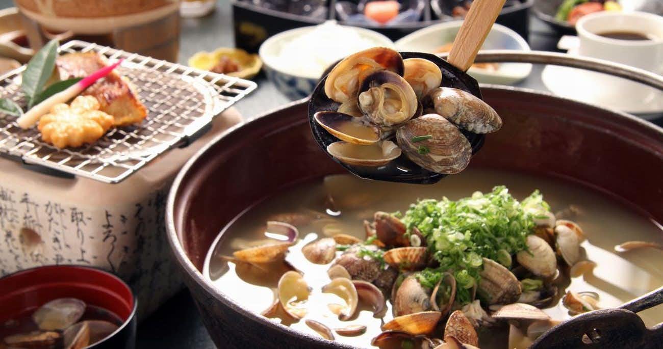 Miyajima Hotel Makoto with grilled seafood and shellfish arranged around a simmering bowl.