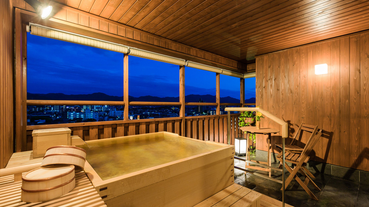 Wooden bath with city lights at dusk.