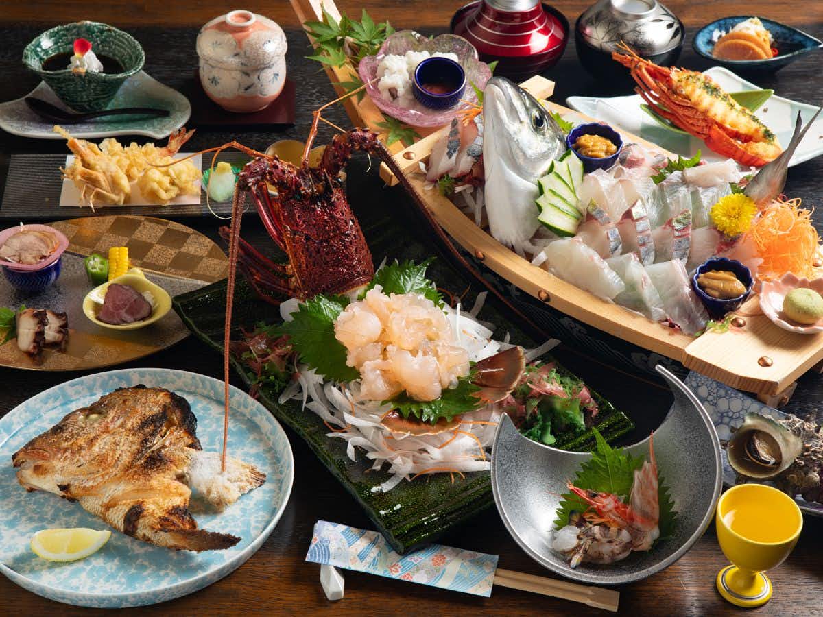 Amakusa Hamabe no Yado Minami with a generous seafood dinner arranged across colorful ceramic dishes.