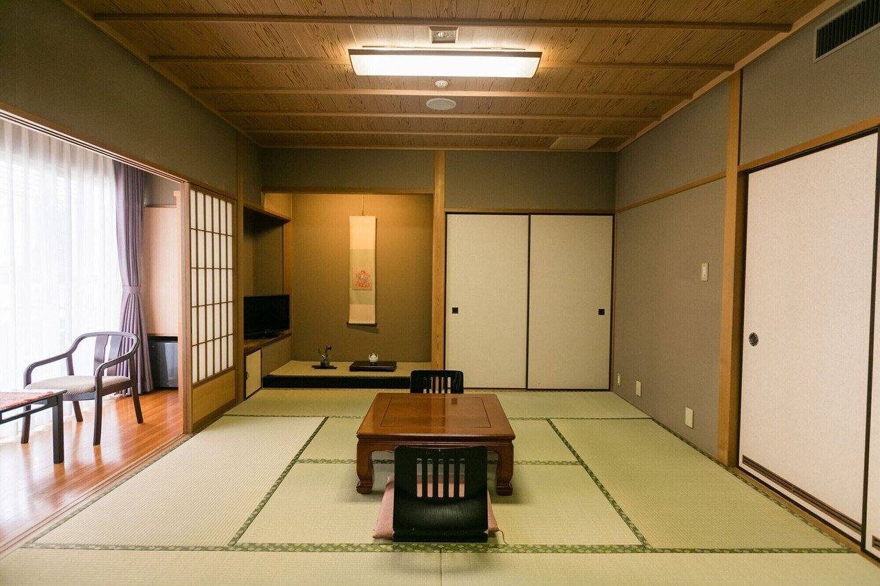 A quiet tatami room has a low table and open floor space.