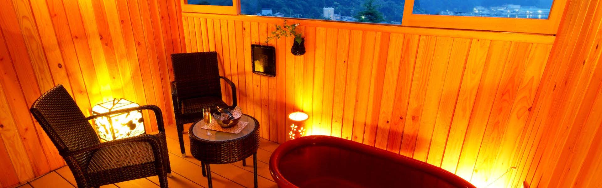 The Kouragi a wood-paneled bathing lounge with a red round tub.