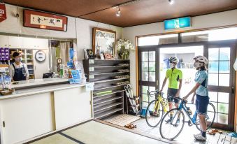 Cyclists with bicycles at the reception counter.