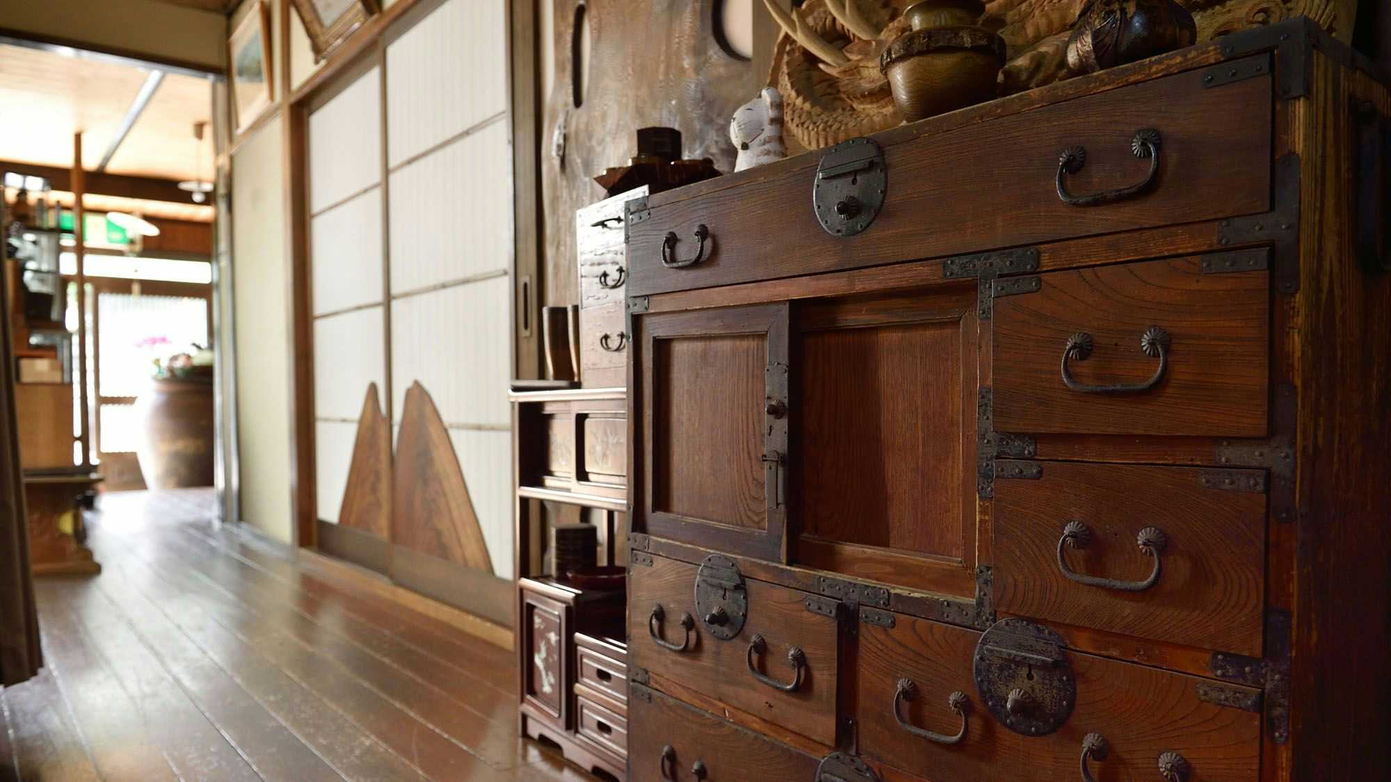 Ryokan Miyukiya with a narrow timber corridor displaying an antique wooden chest.