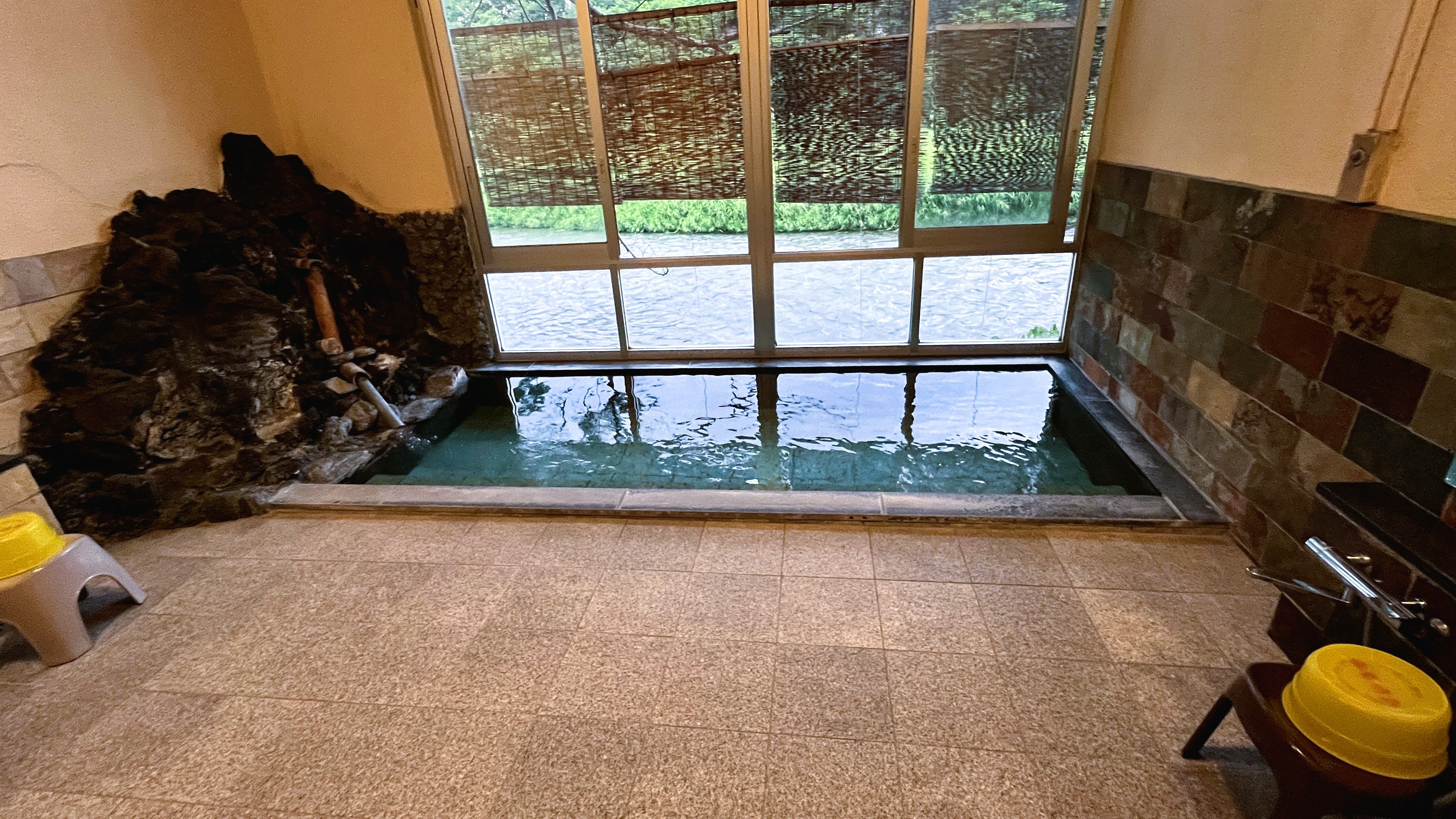 A bright indoor bath beside large windows.