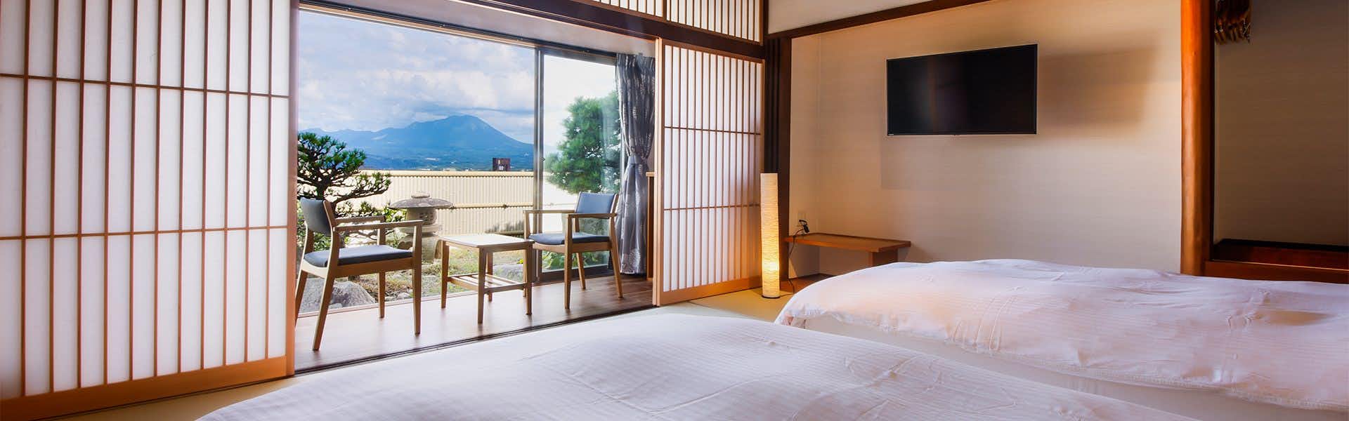 Ikoi-tei Kikuman with a bright bedroom with low bed and mountain-facing windows.
