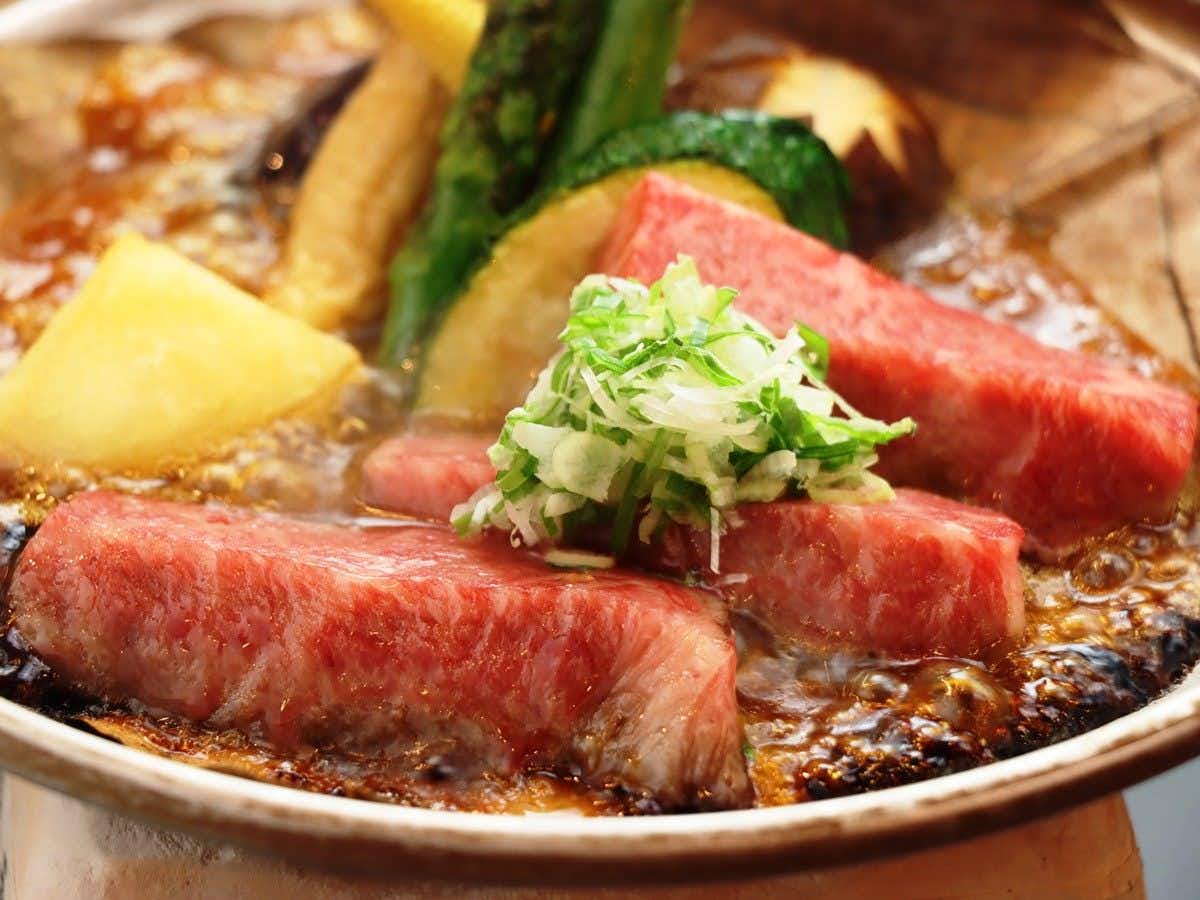 Gero Onsen - Hospitality and Flavor Accommodation, Kissenkan Chikusuitei Thick pink slices arranged in a shallow pan with pale blocks, green garnish, and browned sauce