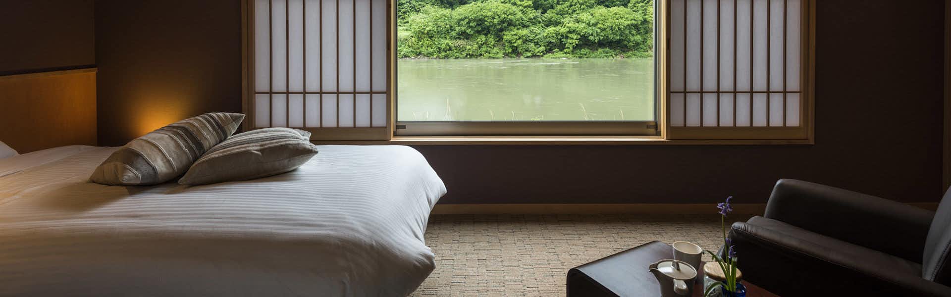 Takamiya Mogamigawa Villa Beni with a modern guest room with a wide bed and river view.