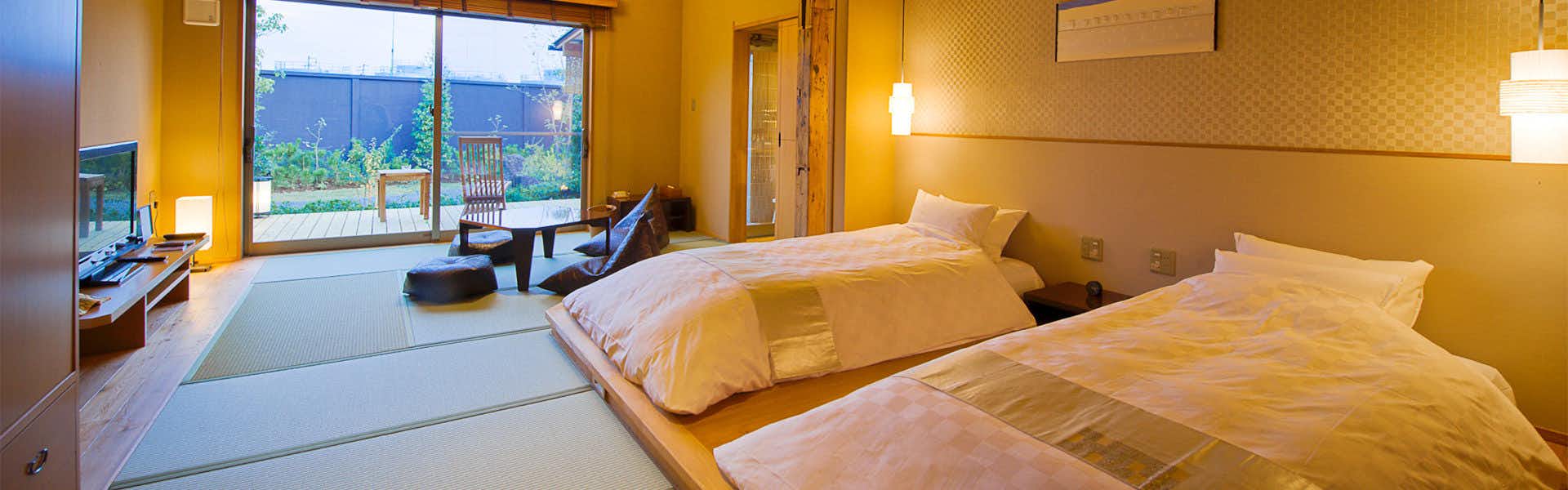 Migiwaya twin beds on tatami facing a small garden terrace