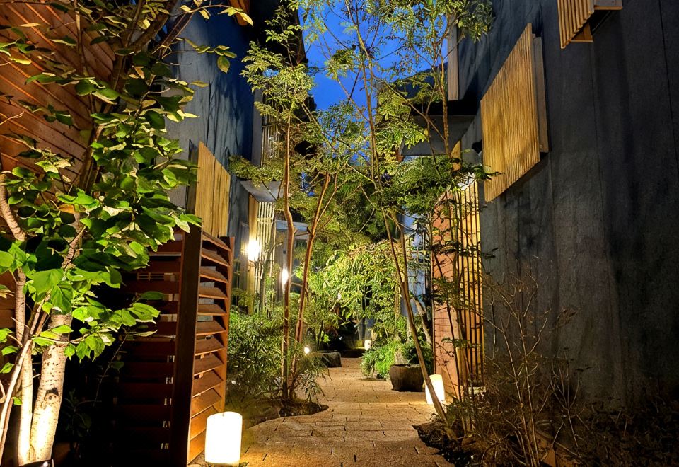 A garden path lined with plants and lanterns.