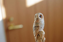 Carved wooden owl ornament displayed against a softly blurred interior.