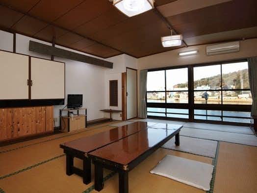 Kappo Ryokan Chikuzenya with this scene, where a tatami room centers a low table beside windows overlooking the harbor.