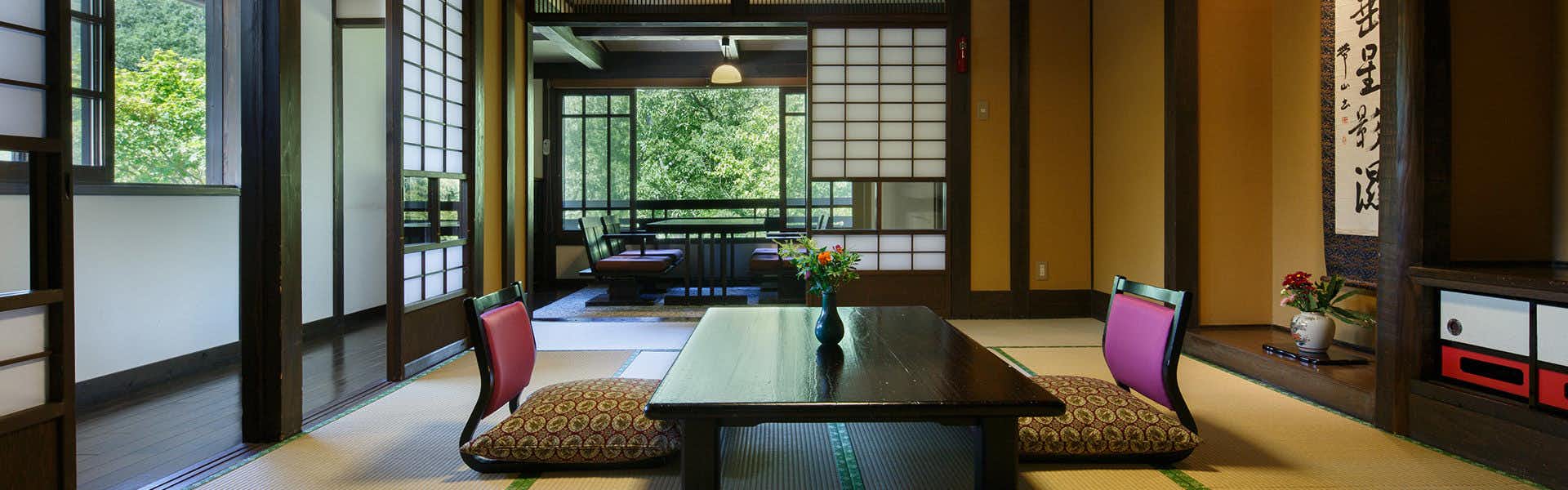 Kurokawa Onsen Yamabiko Inn Yamamizuki with a traditional tatami room with low table and garden windows.