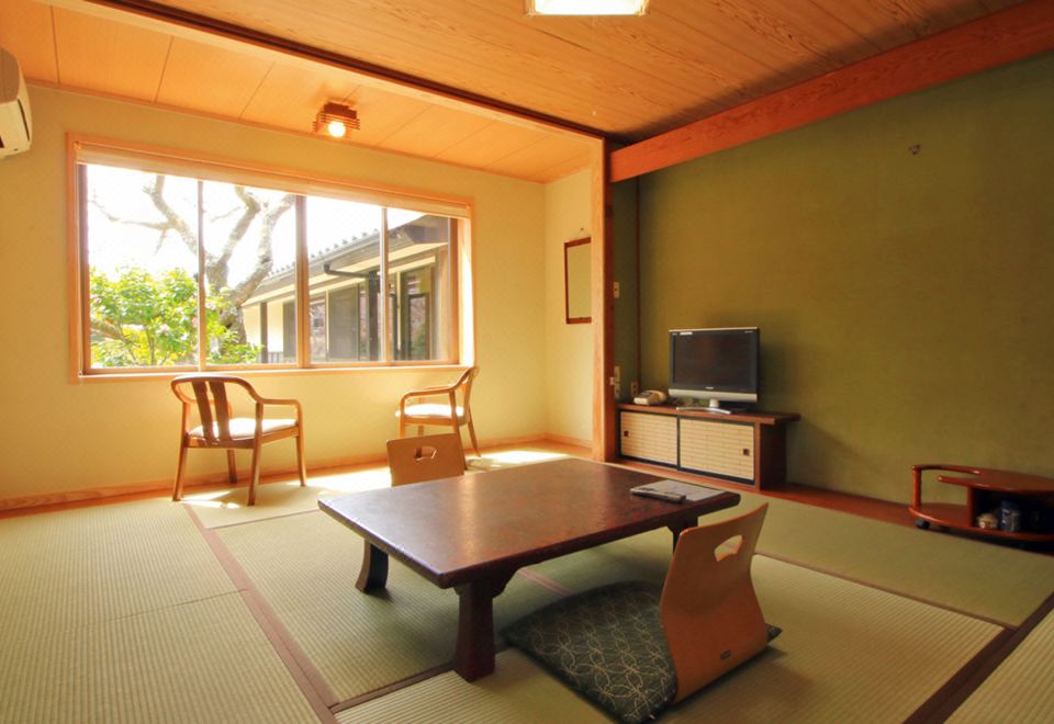 A traditional room with a low table, television, and garden view.