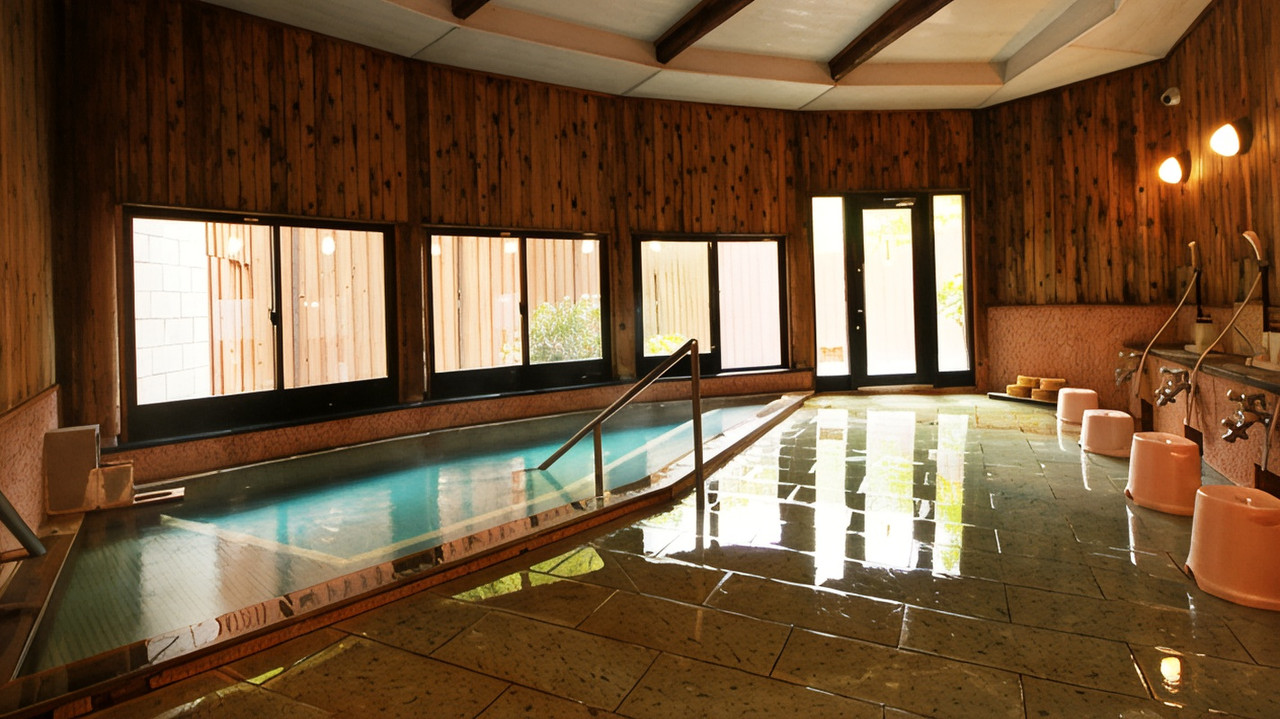 Large indoor bathing pool with wood-paneled walls.