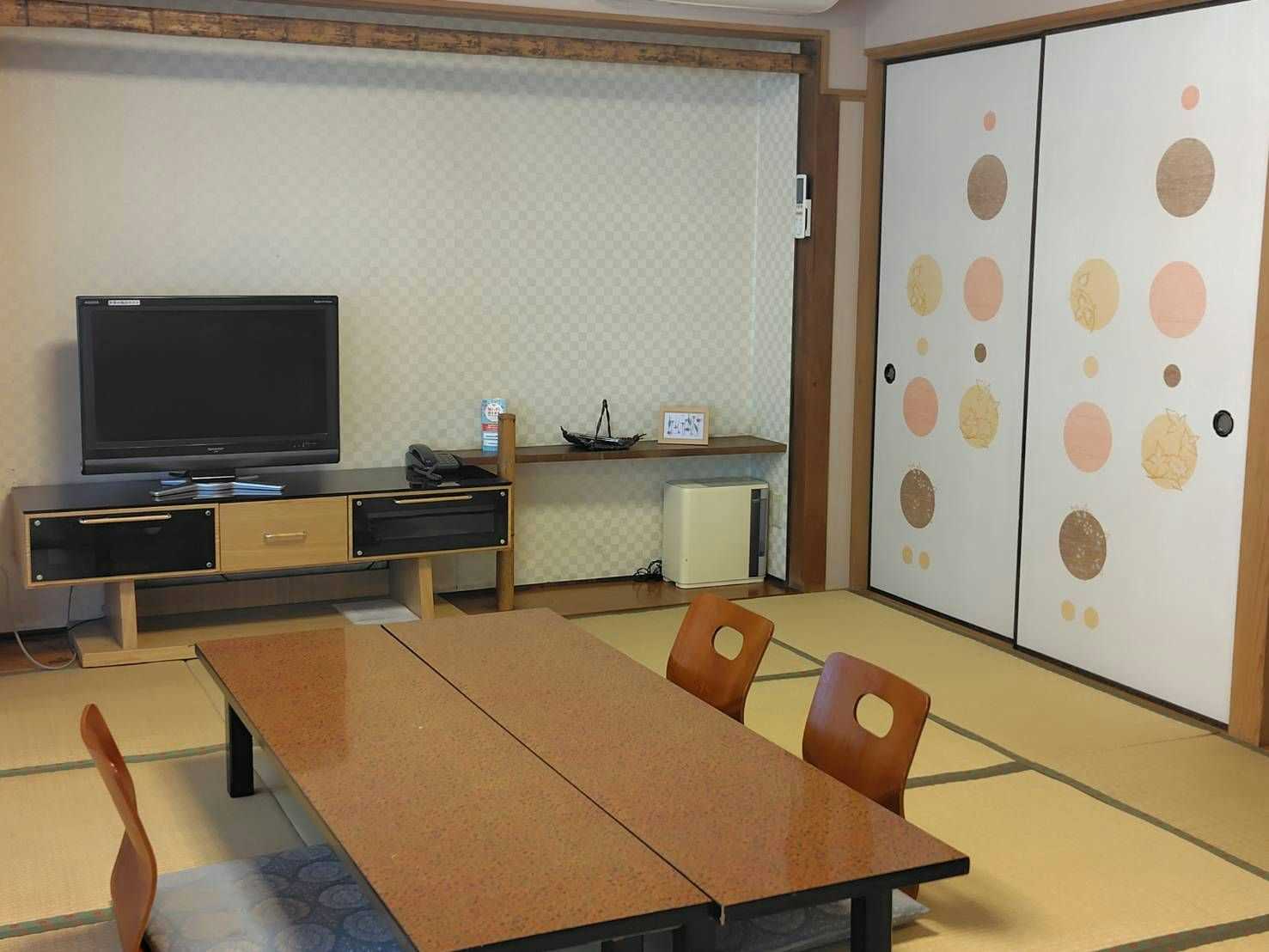 Ryokan Miyakoya a tatami room with a low table and patterned sliding doors.