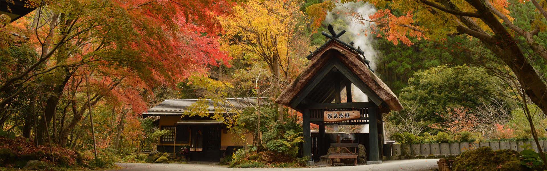Kurokawa Onsen Ryokan Okunoyu with the traditional entrance surrounded by vivid autumn foliage.