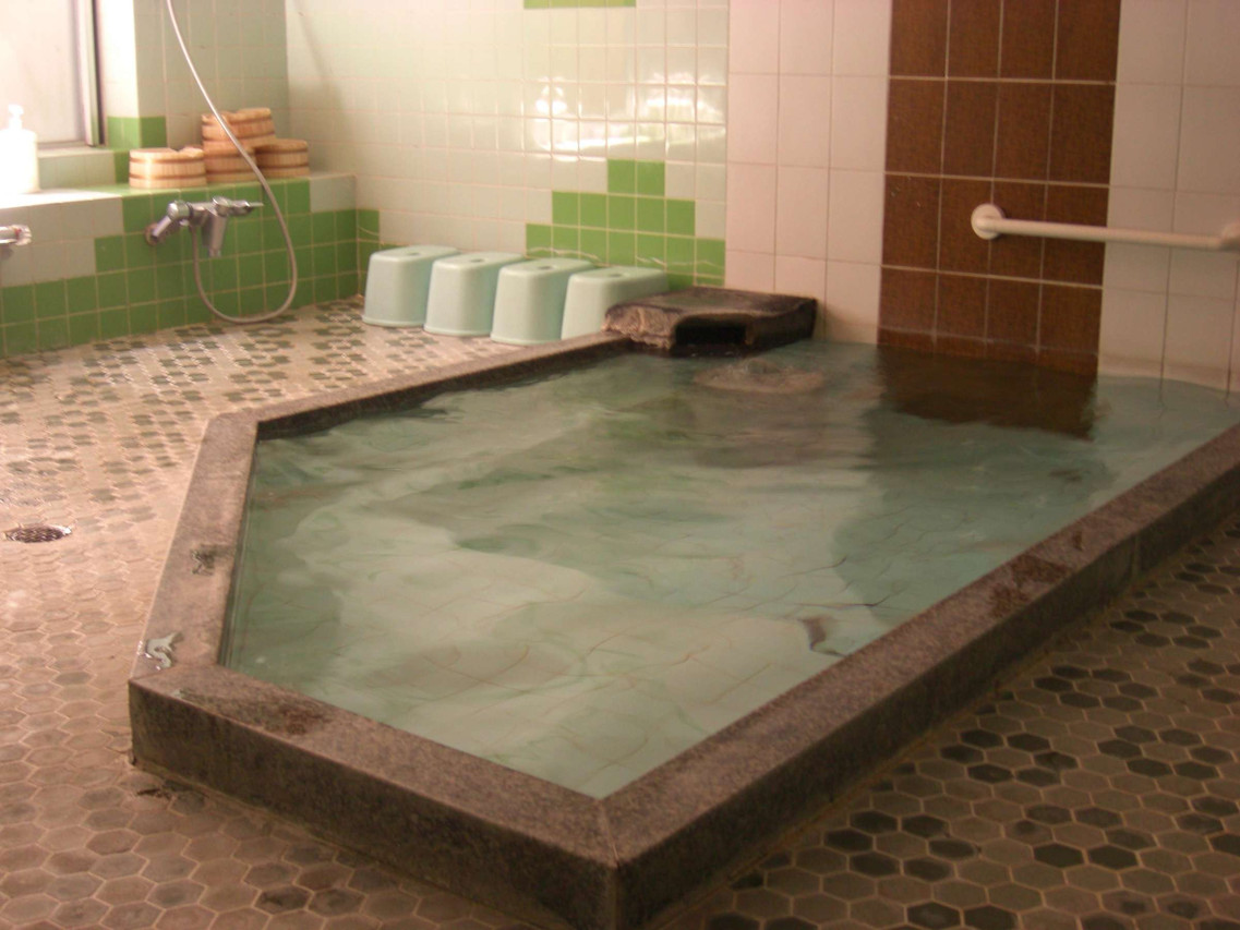 A tiled bath with green and white accents.