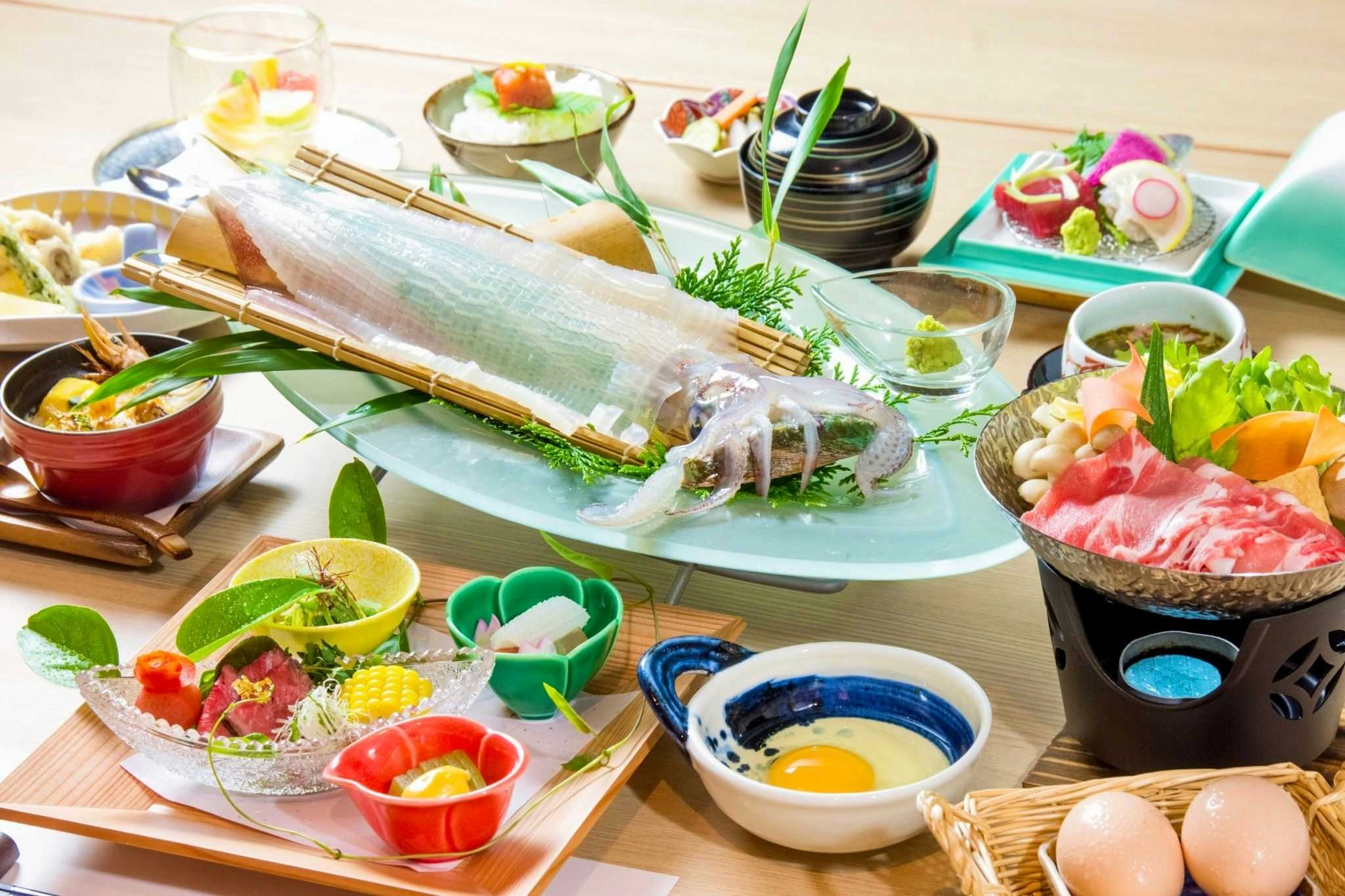 Onyado Hanawarabi with a colorful seafood dinner arranged across small ceramic bowls.