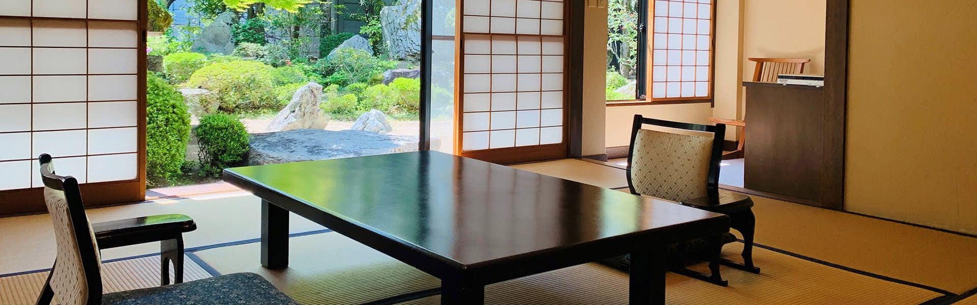 Hagi no Yado Tomoe with a traditional tatami room framing the reflective garden pond.