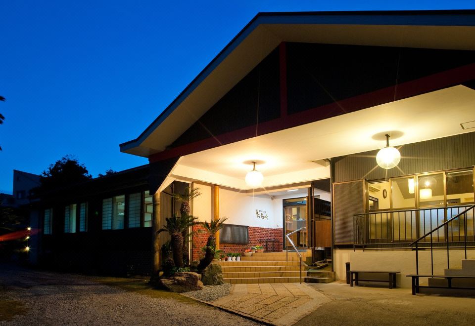 The ryokan entrance illuminated at dusk.