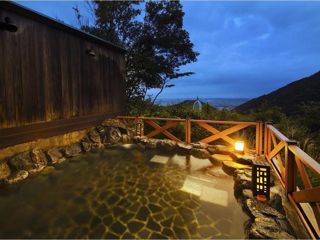 Hotel Yunomoto with an open-air rock bath overlooking the valley at dusk.