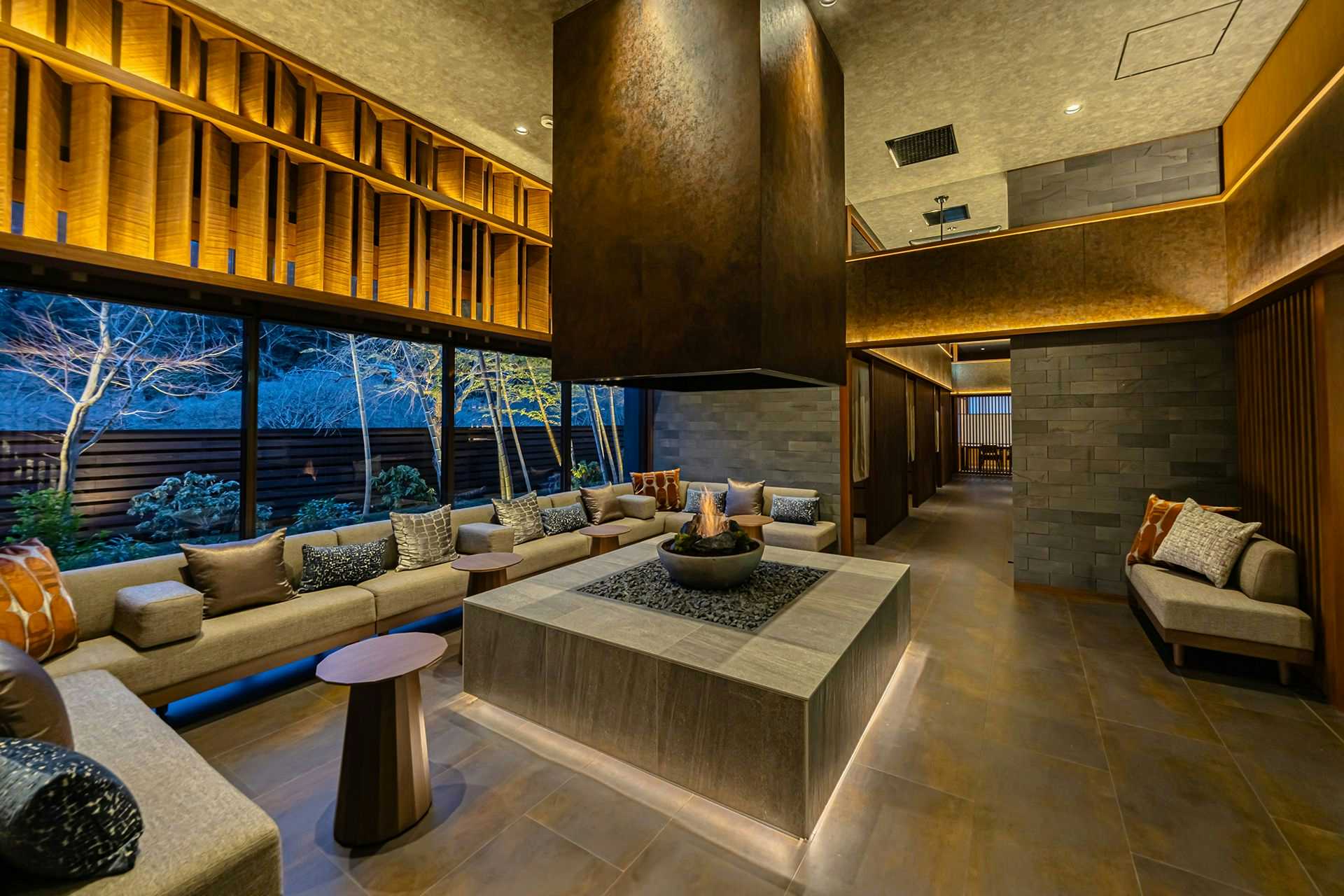 SHINRA YORO VALLEY with a stone-lined lobby with sunken seating and forest windows.