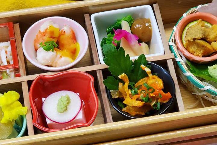 Ueki Onsen Ryokan Kirinoyu with this scene, where nine small seasonal dishes are arranged in a lacquered compartment box.