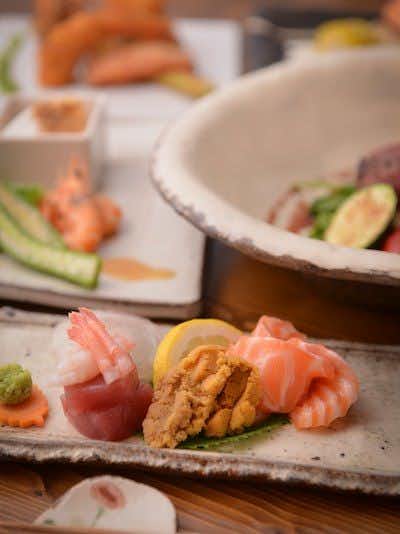 Yuyado Tsurumisou with a colorful seasonal dish presented on dark ceramic tableware.