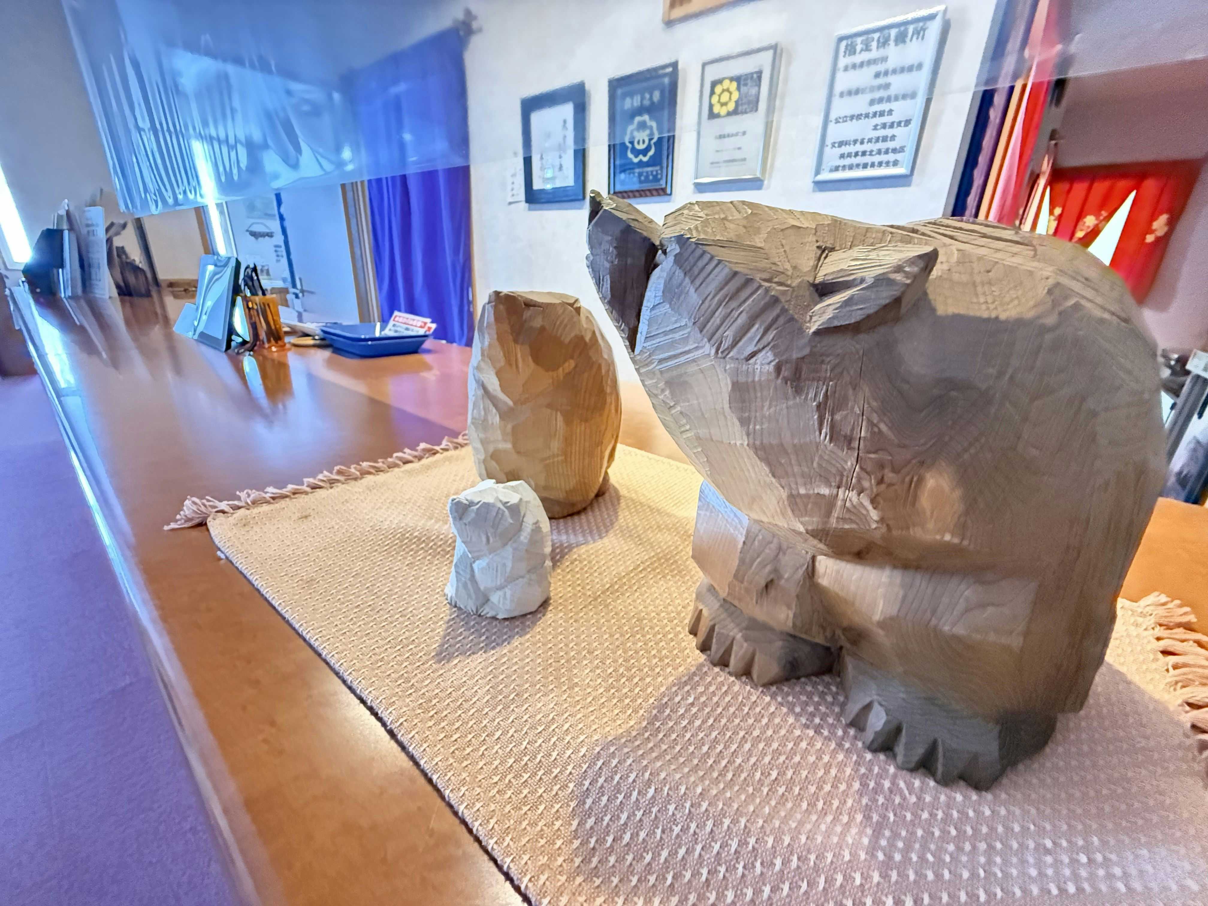 Yakumo Onsen Obokoso with a carved wooden bear displayed in the lobby.