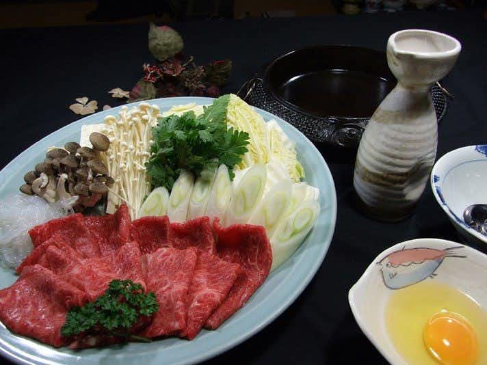Hanegawa Onsen Kadoya Ryokan with sliced horse meat and vegetables arranged around a hot pot.