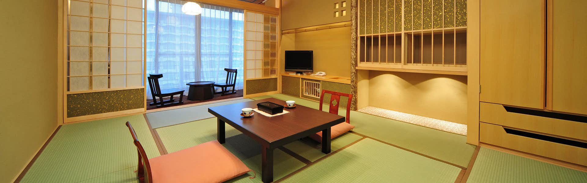Tatsumikan with this scene, where its tatami guest room centers a low table beneath shoji screens and pale woodwork.