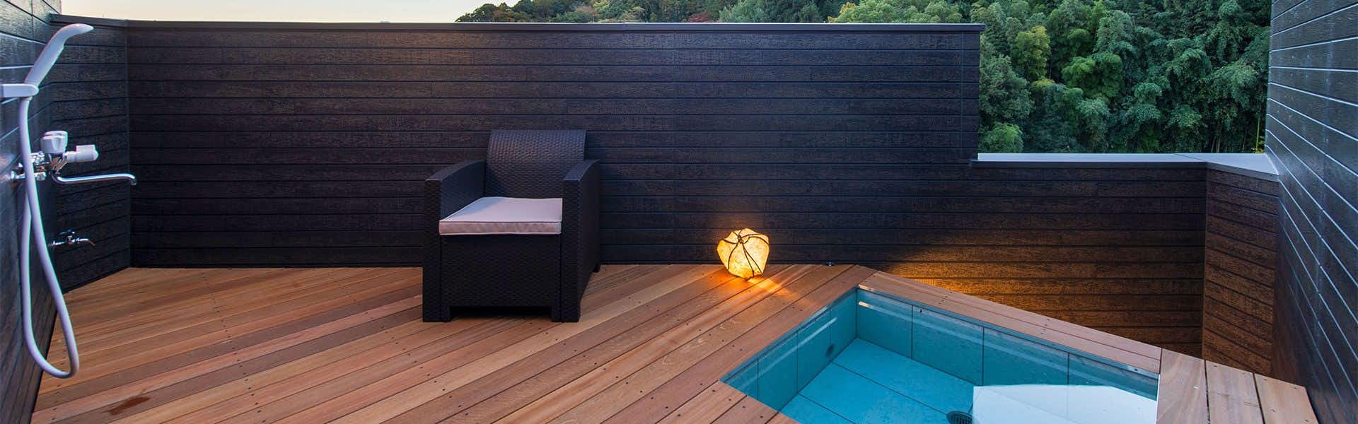 Rakuzan Yasuda: A Tatami-Floored Inn Adorned with Kimonos with a private terrace bath enclosed by dark timber walls.