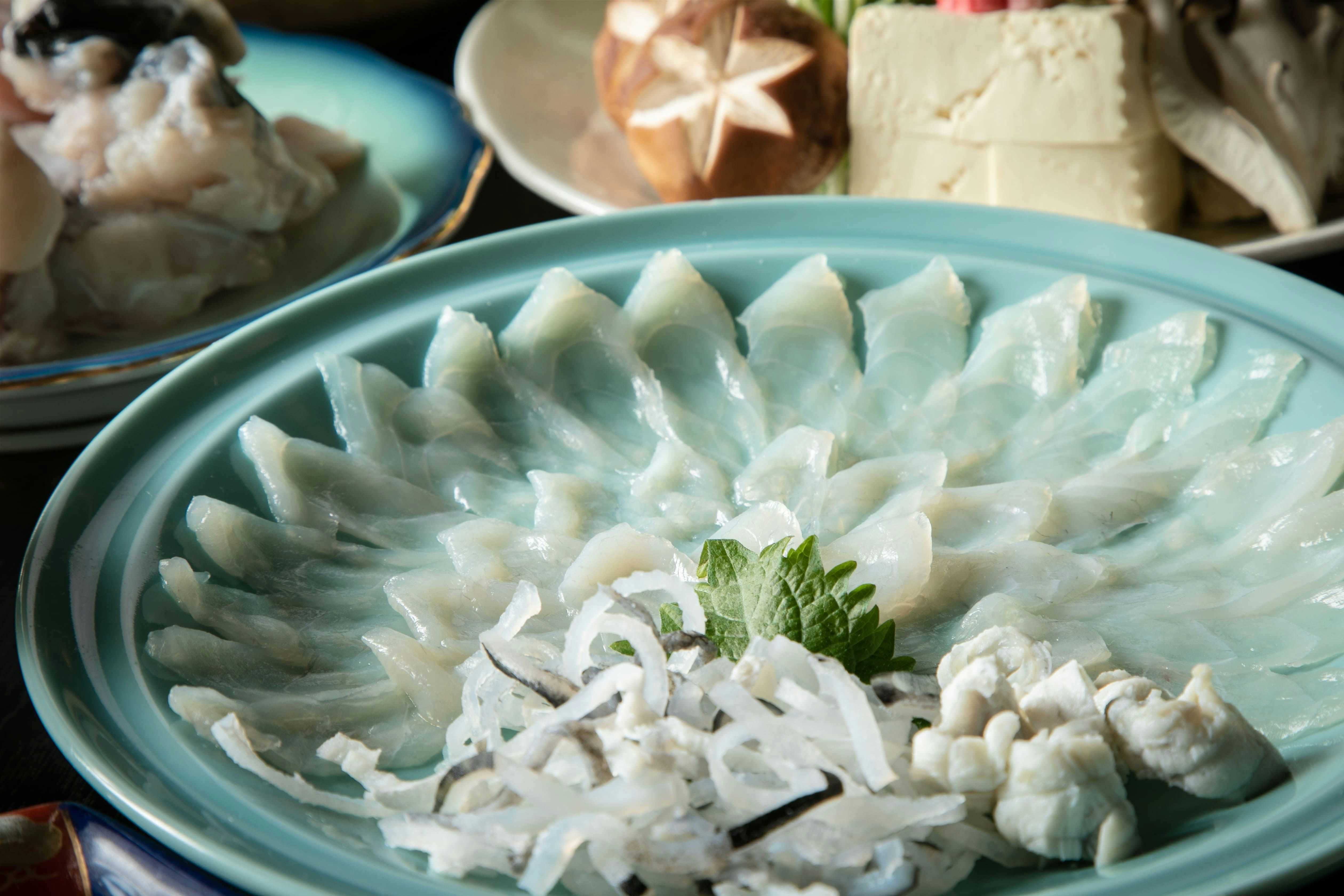 Chikuen Ryokan with thinly sliced fugu arranged in a circular ceramic platter.