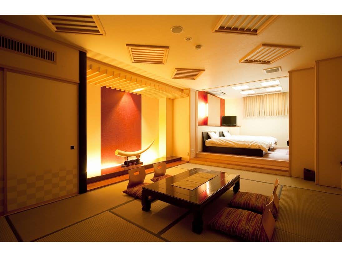 Awara Onsen Seiryukaku with a warm tatami suite with low table and raised western beds.