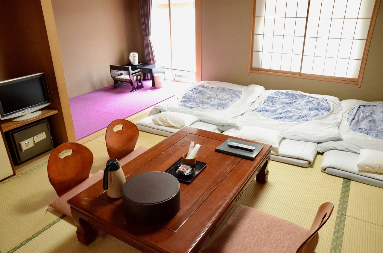 A tatami room pairs futons with a low wooden table.
