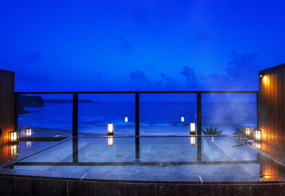 Ocean-facing outdoor bath at dusk.