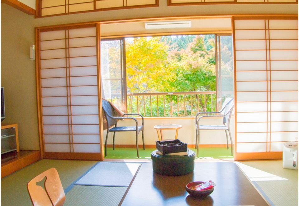 A tatami room opening onto autumn trees.