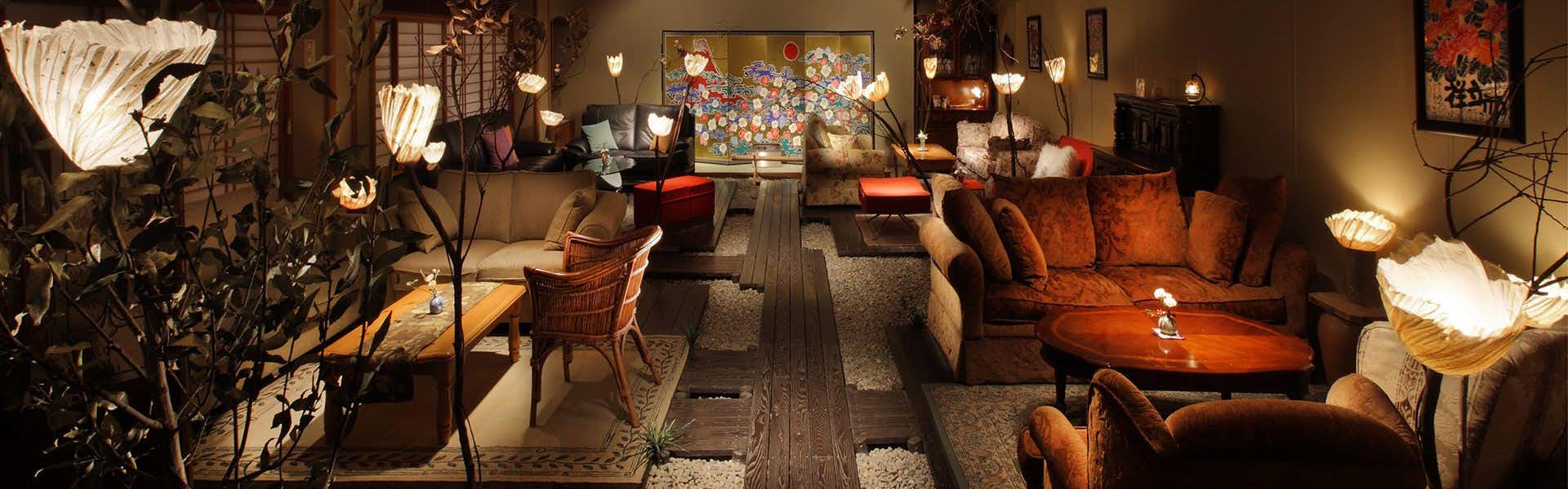 Hanaakari no Yado Tsuki no Ike: An intimate lounge filled with sculptural lamps and artwork.