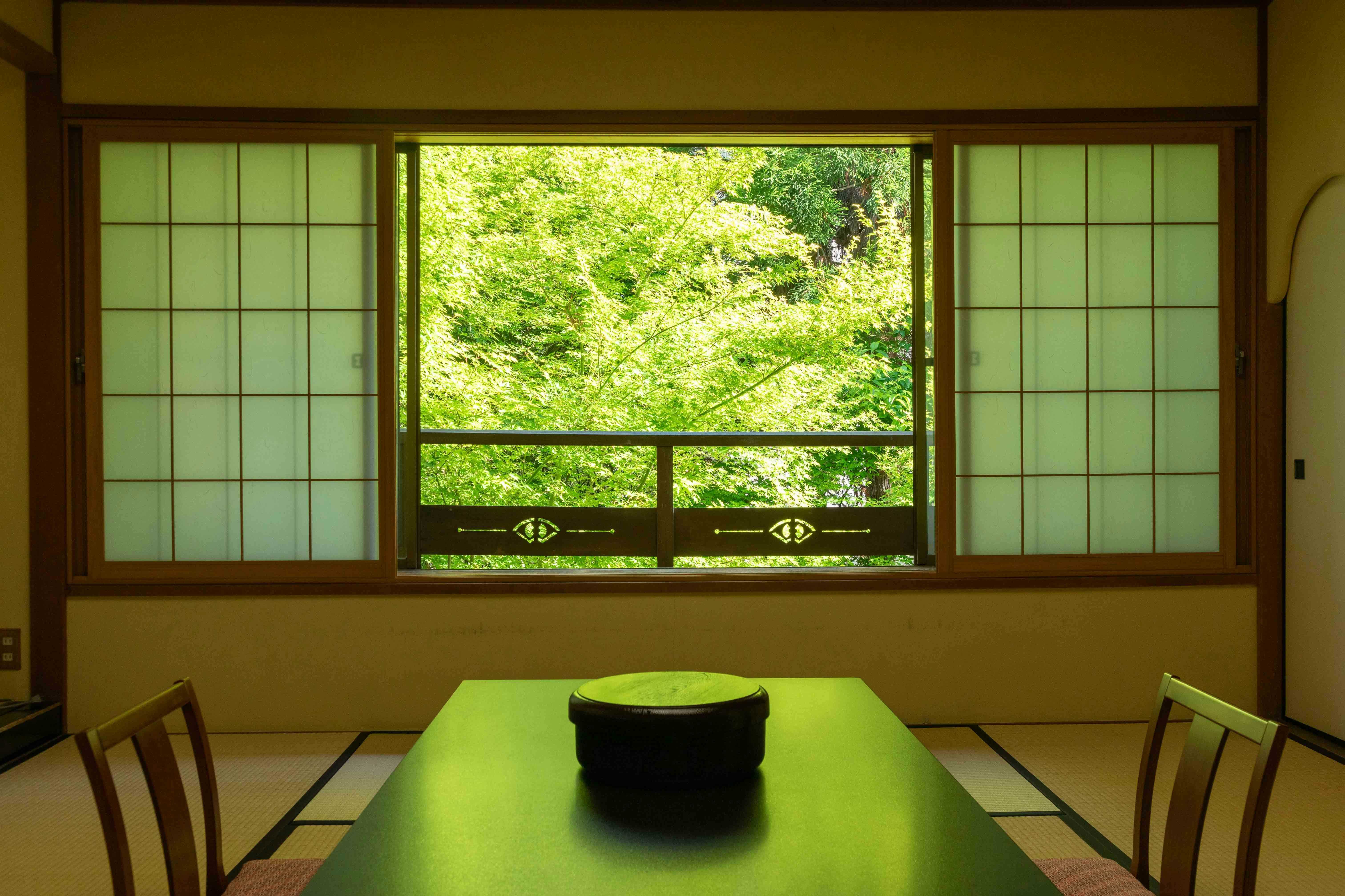 Asama Onsen Izumiso with a tatami room framing bright green foliage.