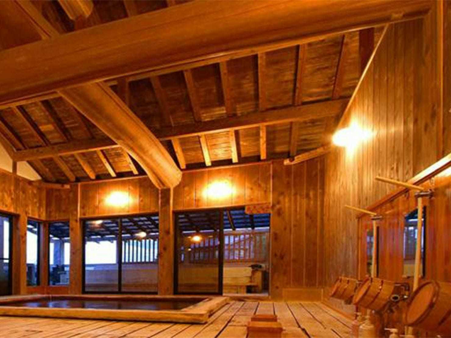Hiogiso with a warmly lit timber bathhouse interior with exposed rafters.