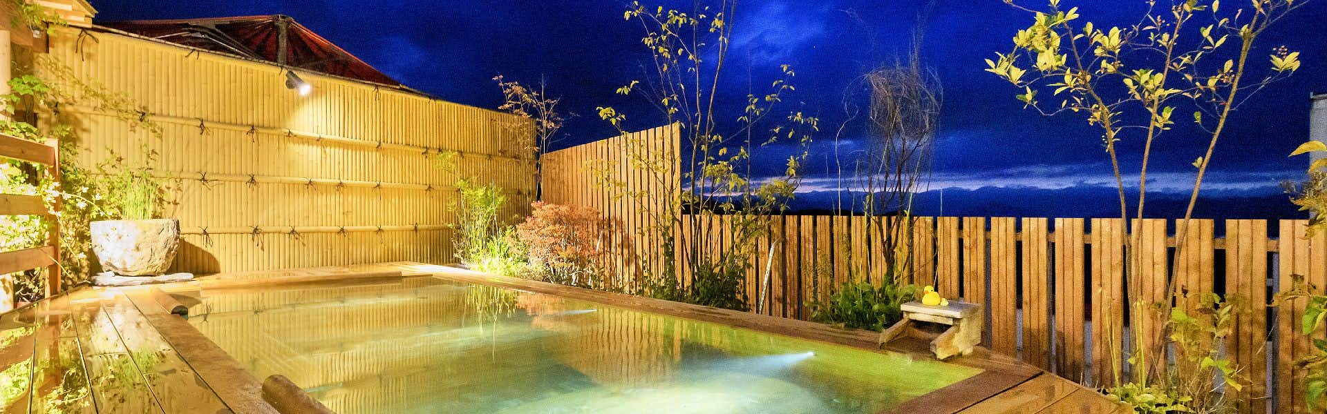 Wagokoro no Yado Omori with an outdoor bath glowing behind timber privacy screens.