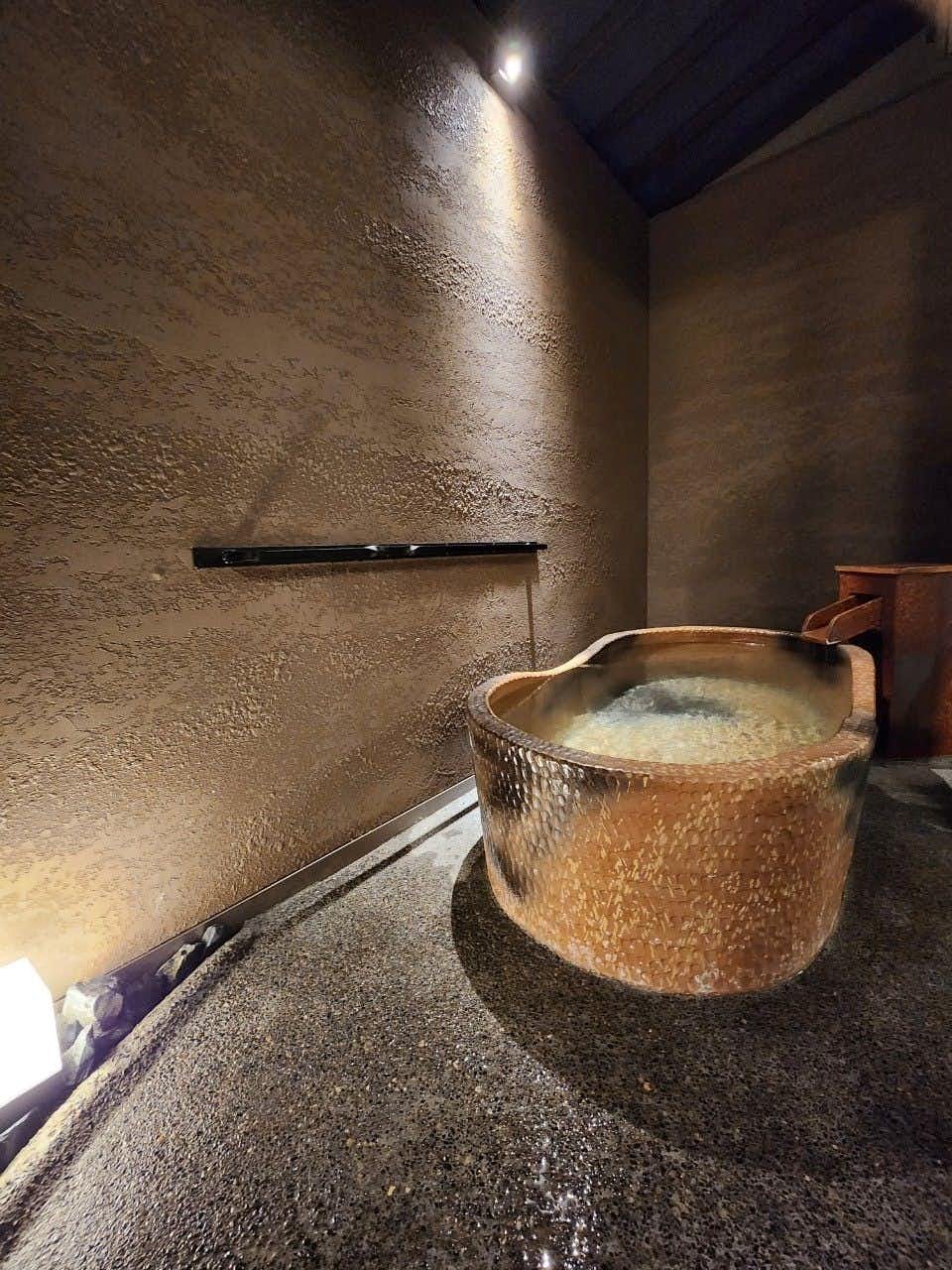 Tomitaya Annex with a private ceramic soaking tub inside a dark stone room.