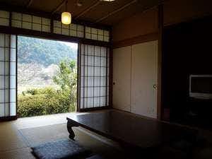 Kurama Onsen Suigetsu with a quiet tatami room overlooking green mountains through open shoji.