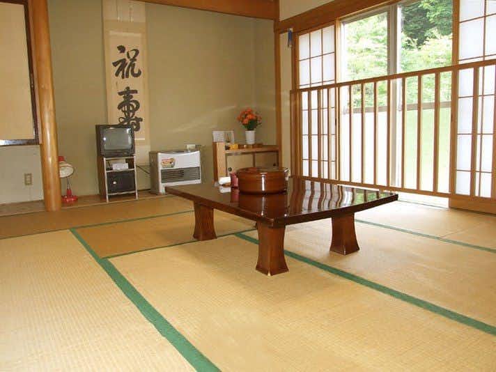 Hanegawa Onsen Kadoya Ryokan with a traditional tatami room with low table and garden windows.