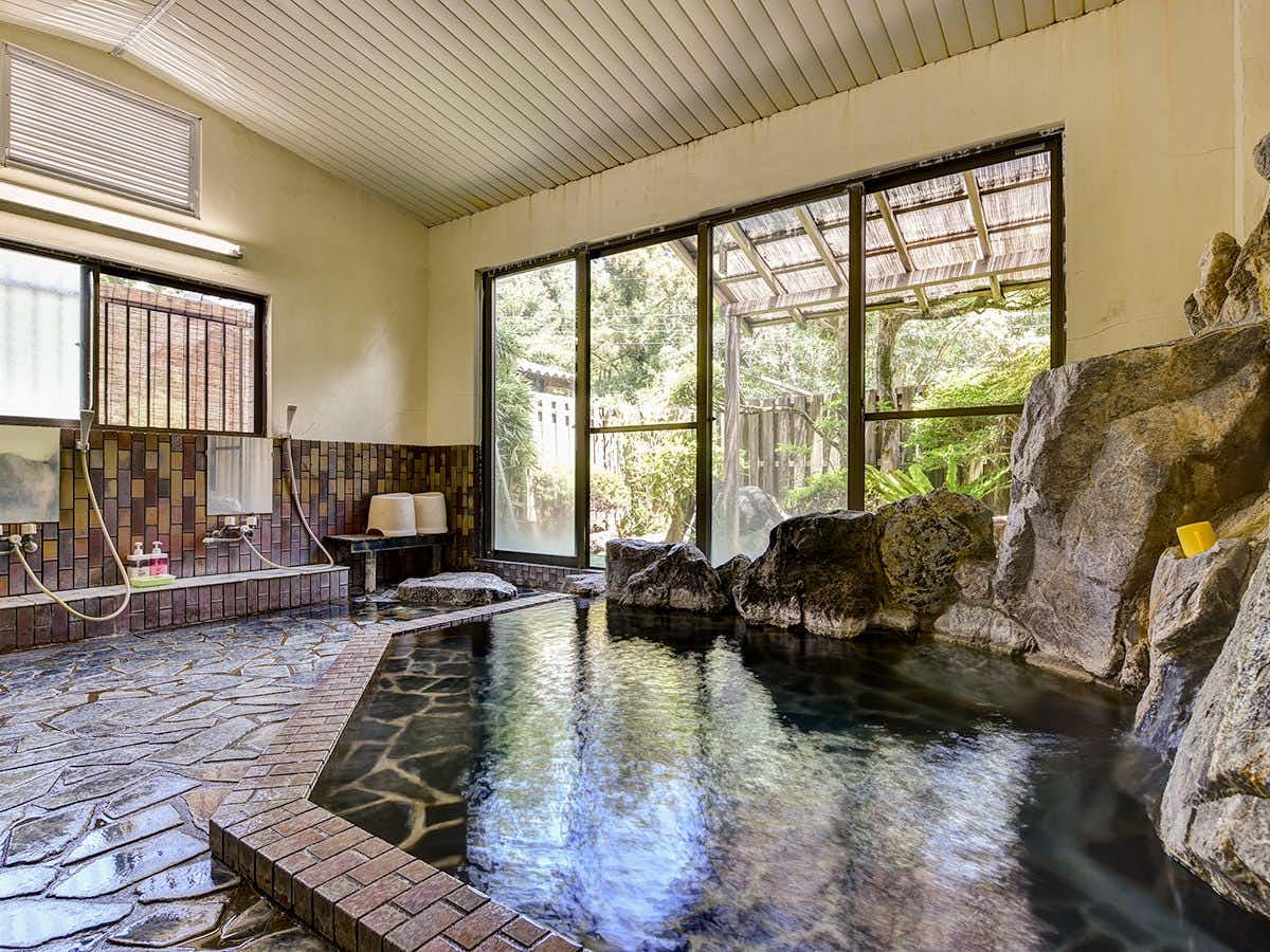 Shibi Onsen Chidori-so with a tiled indoor mineral bath beneath warm timber walls.