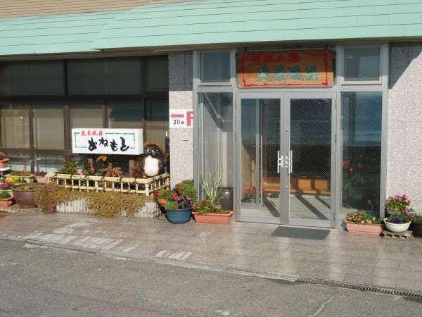 Ryokan Kanemoto with the street-level entrance decorated with flowers and property sign.
