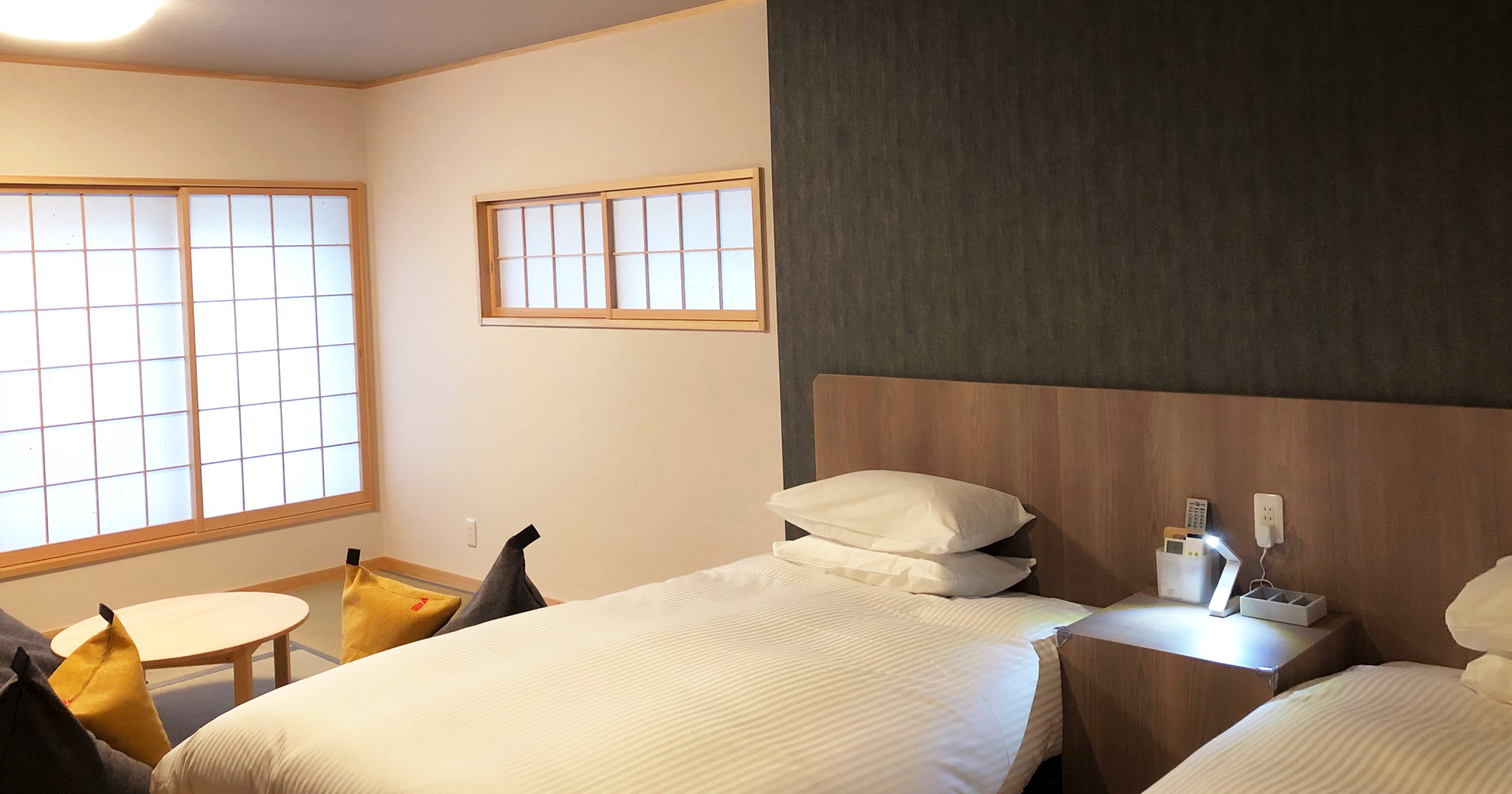 A Japanese guest room with a low table and bed.