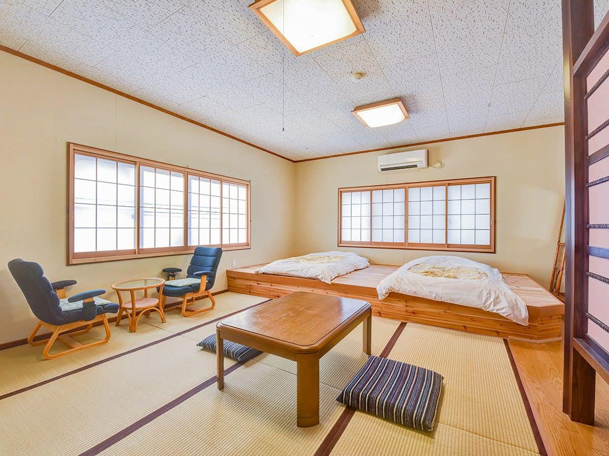 Hatago Shibisou with a tatami bedroom with two futons and window chairs.