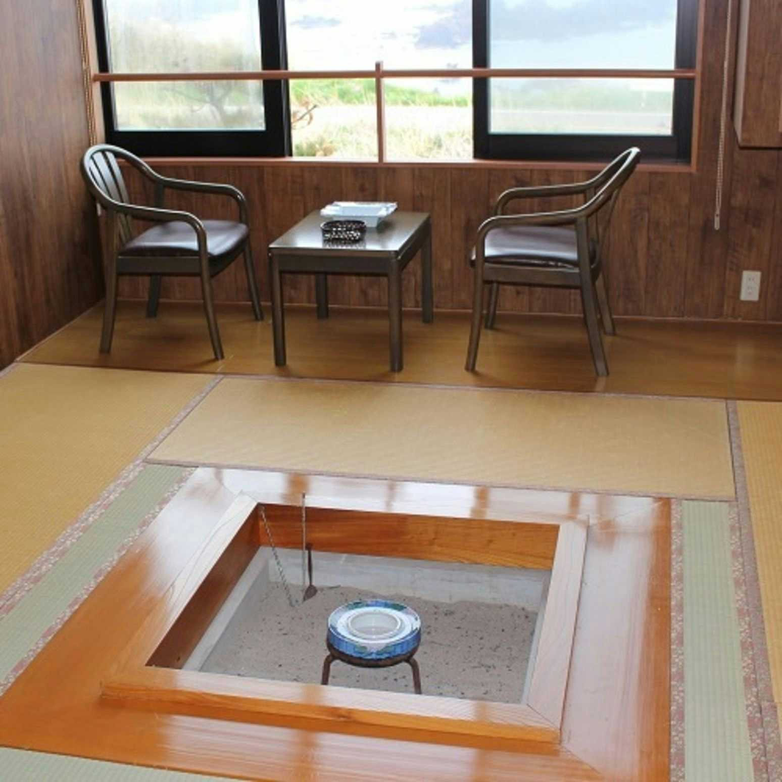 Sado Aikawa Onsen Isaribi no Yado Doyu <Sado Island> with a traditional tatami room centered on a sunken hearth.