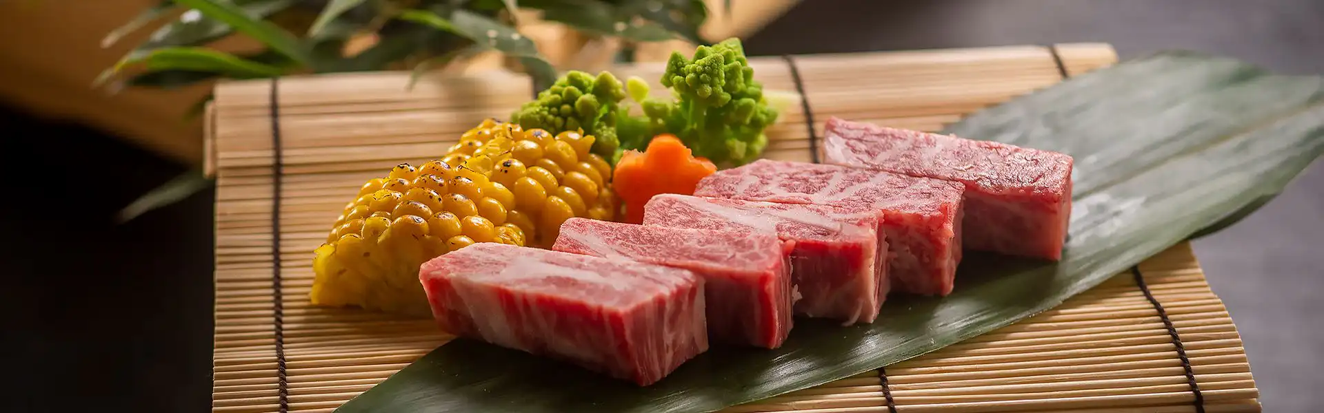 Kawaguchiya Kinosaki Riverside Hotel with this scene, where its marbled meat slices rest beside corn and green vegetables.